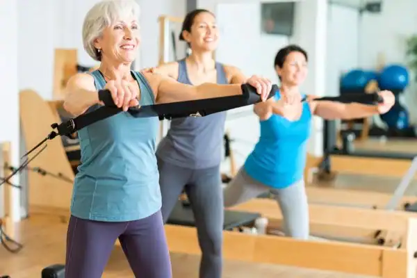 Toning Arms After 60: Empowering Womens Fitness Through Effective Weight Training 2 older woman doing weight training Wickford and resistance in the gym to tone upper arms