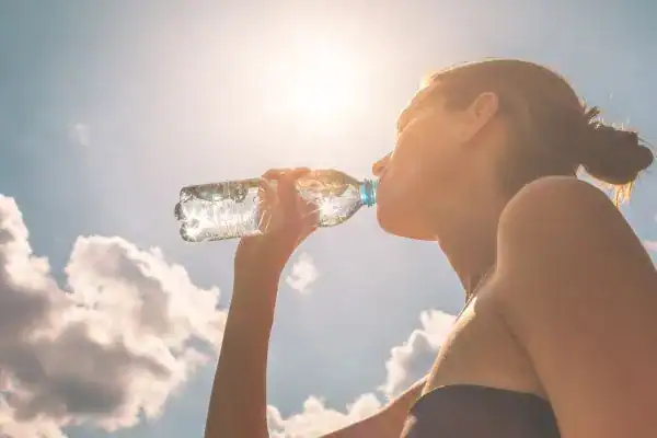 Hydration: The Secret Ingredient for a Toned Stomach and Enhanced Fitness 3 Image of woman drinking water to hydrate Wickford after run.