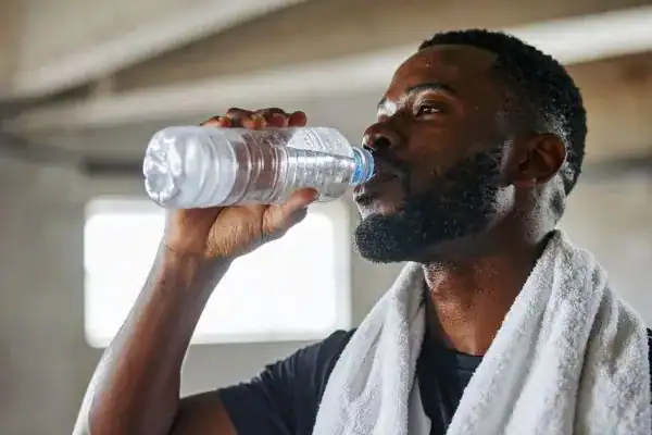 Hydration: The Secret Ingredient for a Toned Stomach and Enhanced Fitness 1 Image of man drinking water to improve hydration Wickford after work out.